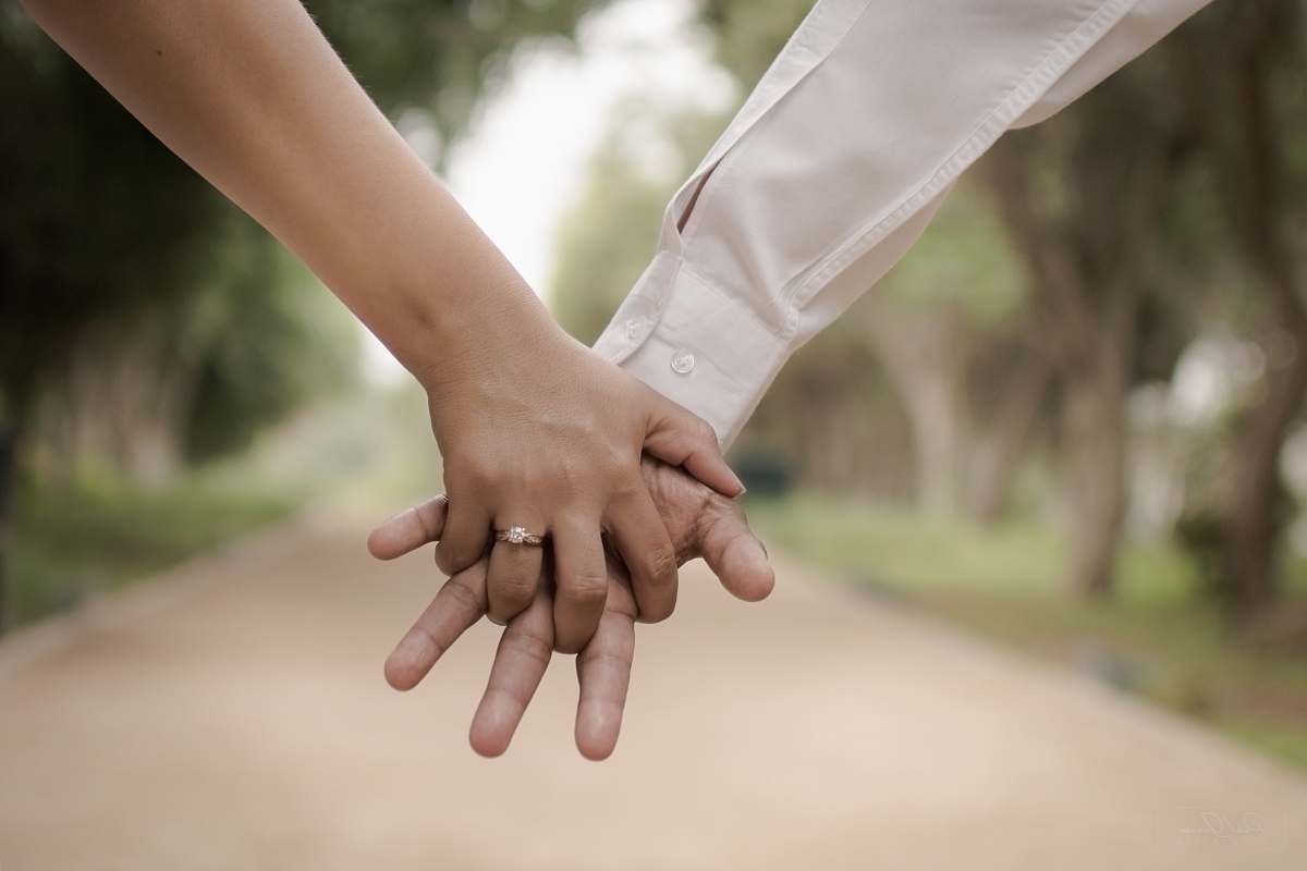 holding hands shallow focus photography of two person holding hands love